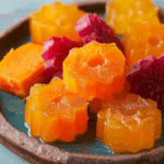 Mango and Carrot Gelatin Bites{ "Description": "Chewy, colorful mango and carrot gelatin bites that are naturally sweet, nutrient-packed, and collagen-rich. Perfect for kids, adults, and a guilt-free snack or lunchbox treat.", "Ingredients": "<ul><li>1 ½ cups diced mango chunks (defrosted if frozen)</li><li>1 medium carrot, steamed until soft</li><li>2 tablespoons honey (or more to taste)</li><li>¼ cup water</li><li>5 tablespoons grass-fed beef gelatin powder</li></ul>", "Instructions": "<ol><li>Line a 9-inch loaf pan with parchment paper and lightly coat with coconut oil spray.</li><li>In a high-speed blender, combine mango, steamed carrot, honey, and water. Blend until silky smooth, about 5 minutes. Taste and add more honey if needed.</li><li>Pour the puree into a saucepan. Sprinkle gelatin evenly on top and let sit for 5 minutes without stirring.</li><li>Place saucepan over medium heat and whisk continuously until the gelatin is fully dissolved and the mixture is smooth. Do not boil.</li><li>Pour mixture into the prepared pan, smoothing the surface.</li><li>Refrigerate for 3–4 hours, or until set.</li><li>Once firm, cut into cubes or use cookie cutters for fun shapes. Store in the fridge for up to 5 days.</li></ol>", "Notes": "<ul><li>Use maple syrup or agave instead of honey for a different sweetener.</li><li>Add orange juice or zest for a citrusy twist.</li><li>Try sweet potatoes or parsnips in place of carrot for a new flavor.</li><li>Use agar-agar or another plant-based gelatin for a vegan version.</li><li>Blend in a few strawberries or pineapple for a tropical mix.</li><li>Do not reheat; these bites are meant to be eaten chilled.</li></ul>", "Details": { "Prep Time": "20 minutes", "Cook Time": "10 minutes", "Chill Time": "3–4 hours", "Total Time": "30 minutes active, plus chilling", "Yield": "About 75 bite-sized pieces", "Category": "Snack", "Method": "Blending and chilling", "Cuisine": "American", "Diet": "Gluten-Free, Naturally Sweetened" }, "Keywords": "mango carrot gelatin, healthy snack, fruit bites, collagen-rich snack, kids lunchbox treat, natural sweetener", "Nutrition": { "Serving Size": "5 bites", "Calories": "45", "Sugar": "8g", "Sodium": "5mg", "Fat": "0g", "Saturated Fat": "0g", "Unsaturated Fat": "0g", "Trans Fat": "0g", "Carbohydrates": "11g", "Fiber": "1g", "Protein": "2g", "Cholesterol": "0mg" } }